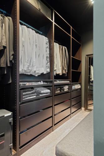 a walk in closet with black cabinets and open shelving at Moderne hus midt i Lofoten in Ballstad