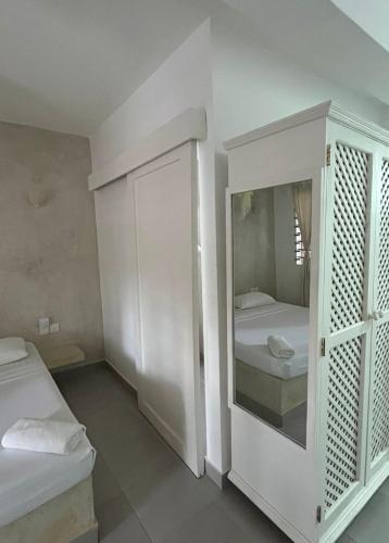 a white room with two beds and a mirror at Studio Leliya 2 in Malindi