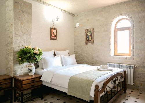 a bedroom with a large white bed and a window at Castel Unghern in Ivancea