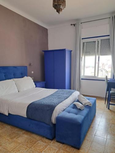 a bedroom with a blue bed and a blue ottoman at El Muniria in Tangier