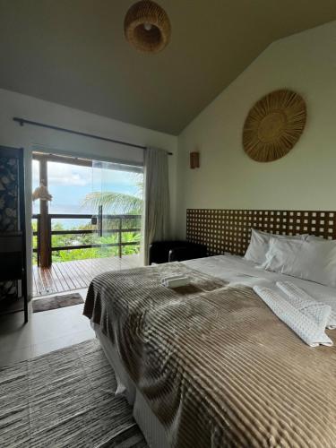 a bedroom with a bed with a view of the ocean at Casa do Ney in Fernando de Noronha