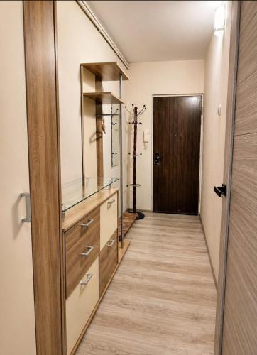 a hallway with a wooden door and a wooden floor at Viktorija Apartament in Liepāja
