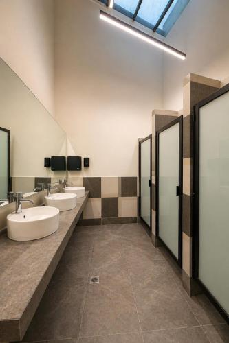 a bathroom with three sinks and three mirrors at Morada Luna Centro Histórico in Mexico City