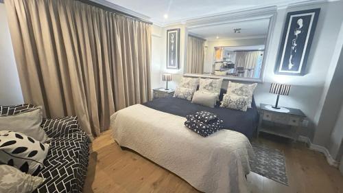a bedroom with a bed and a couch at Artzy's Studio - 1km to Olivedale Clinic in Northriding