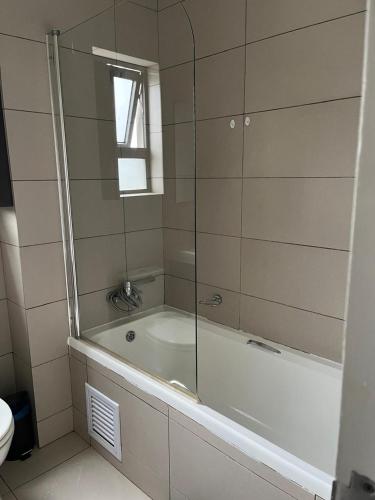 a bathroom with a tub with a window and a toilet at Dainfern Luxe Living - 2 Bed in Fourways