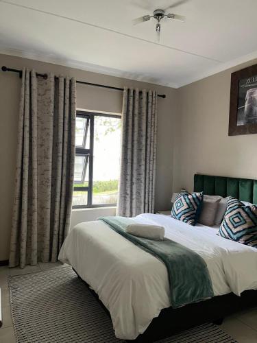 a bedroom with a large bed and a window at Dainfern Luxe Living - 2 Bed in Fourways