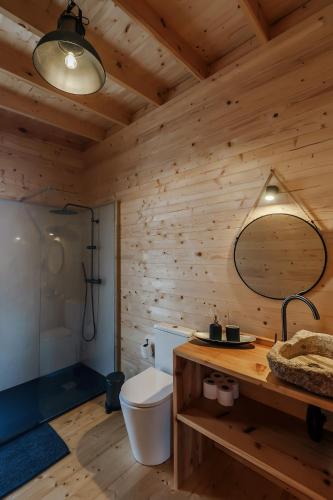 a wooden bathroom with a toilet and a mirror at Recanto Terra Alta in São Roque do Pico