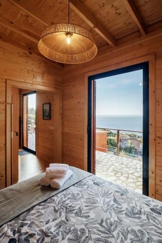 a bedroom with a bed and a large glass door at Recanto Terra Alta in São Roque do Pico