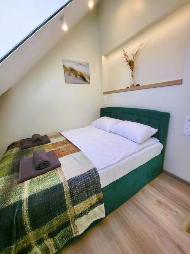 a bedroom with a bed with a blanket on it at Ežiukų rojus in Neringa