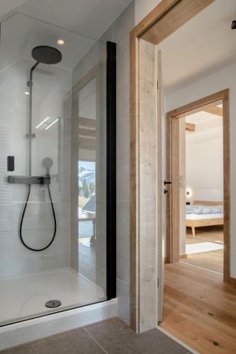 a bathroom with a shower and a glass door at Das Detox Almhaus in Pusterwald