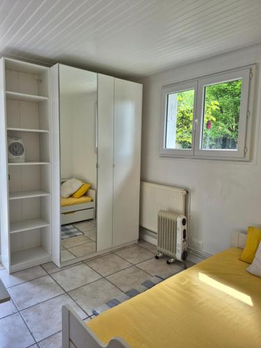 a bedroom with a bed and a closet and a window at Studio Neuf et indépendant in LʼÉtang-la-Ville