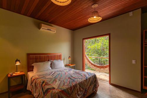 a bedroom with a bed and a large window at Serra do Juá Pousada de Campo in Pirenópolis