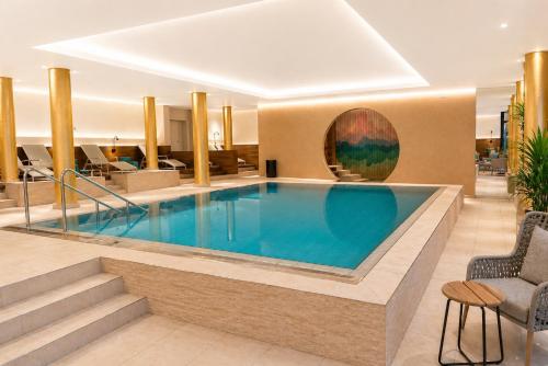 a large swimming pool in a hotel lobby at AMBER HOTEL Bavaria in Bad Reichenhall