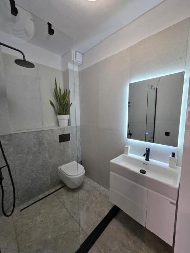 a bathroom with a sink and a toilet and a mirror at Sun & Moon Studio Afitos in Afitos