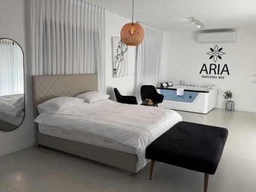 a bedroom with a bed and a desk and a mirror at אריאה צימר בוטיק לזוגות Aria in HaZore‘im