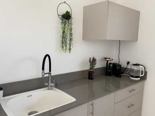 a kitchen with a sink and a white cabinet at אריאה צימר בוטיק לזוגות Aria in HaZore‘im