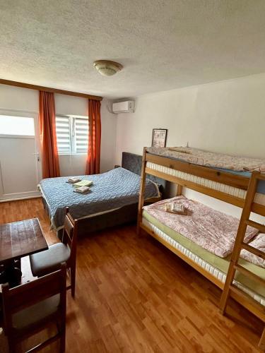 a bedroom with two bunk beds and a table at Apartment Lotika in Višegrad