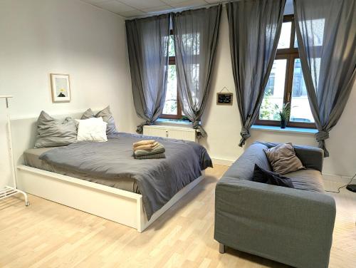 a bedroom with a bed and a couch at Grosses Zimmer im Zentrum Elise , ruhig & gemuetlich in Chemnitz
