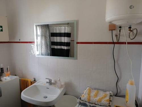 a bathroom with a sink and a toilet and a mirror at Casa Algiana - Private Pool in Loulé