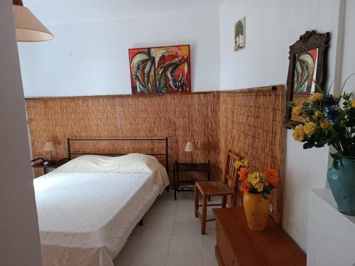 a bedroom with a bed and a vase of flowers at Casa Algiana - Private Pool in Loulé
