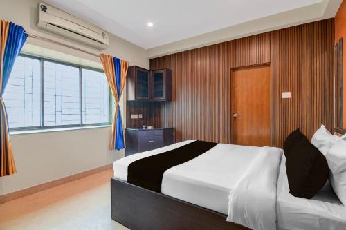 a bedroom with a bed and a large window at Hotel O Newtown worldstay in Thākurdwari