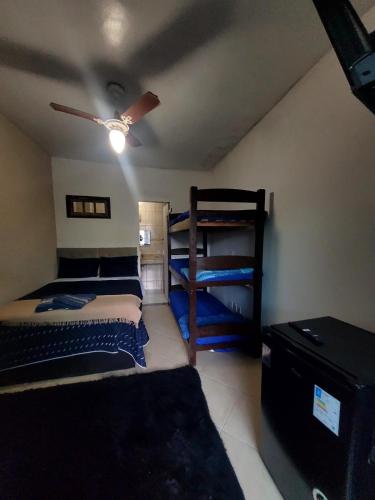 a bedroom with two bunk beds and a ceiling fan at Pousada Terraço do Peró Cabo Frio Há 200 metros da Praia in Cabo Frio