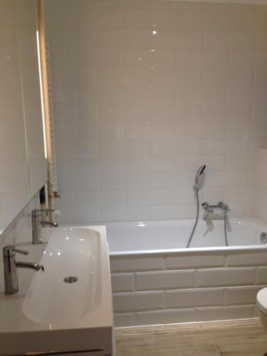 a bathroom with a sink and a bath tub at Appartement 2 chambres avec balcon terrasse in Villars-sur-Glâne