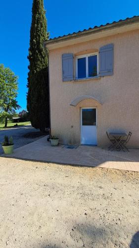 a house with a white door and a bench in front of it at Hébergement dans le vignoble du Mâconnais in Azé