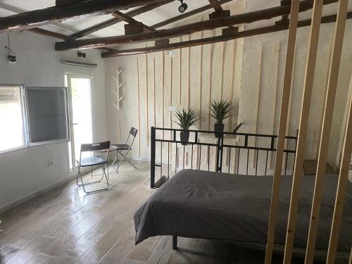a bedroom with a bed and a table and chairs at Mi pequeño refugio in Constantina