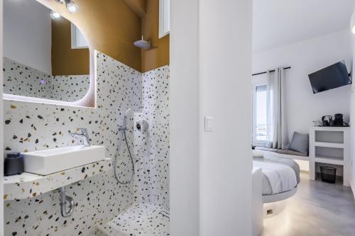 a bathroom with a sink and a bed in a room at Uncle John's Guesthouse in Skopelos Town
