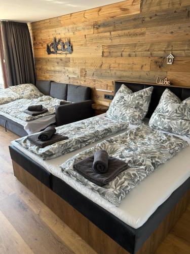 two twin beds in a room with wooden walls at Staufen Stern in Oberstaufen