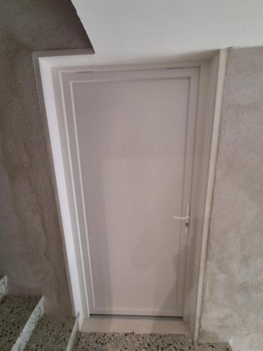 a white door in a room with stairs at The Cévennes break in Anduze