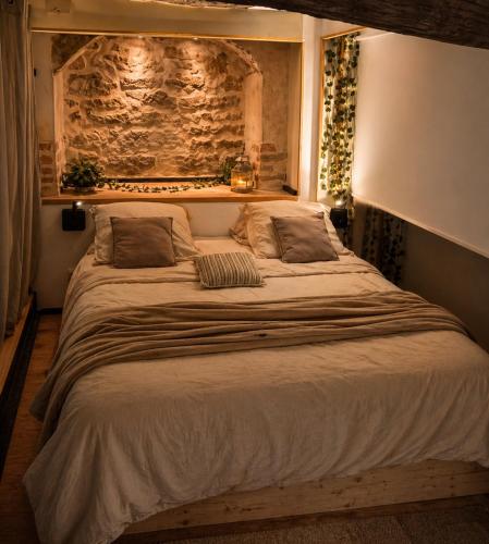 a large white bed in a bedroom with lights at Suite spa Romantique avec piscine privée cosy clim in Coligny