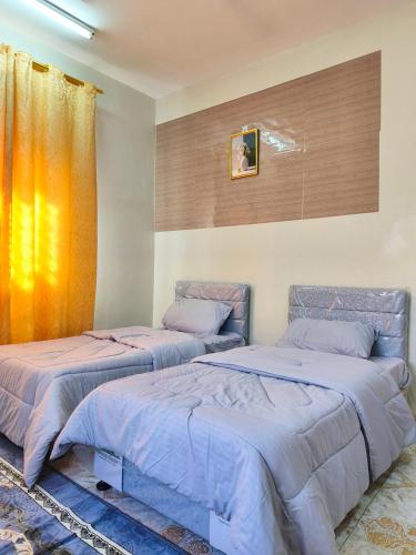 two beds sitting next to each other in a bedroom at شقة مفروشة بمدينة نزوى in Fulūj Sayghah