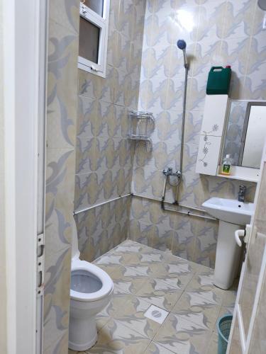 a bathroom with a toilet and a sink at شقة مفروشة بمدينة نزوى in Fulūj Sayghah
