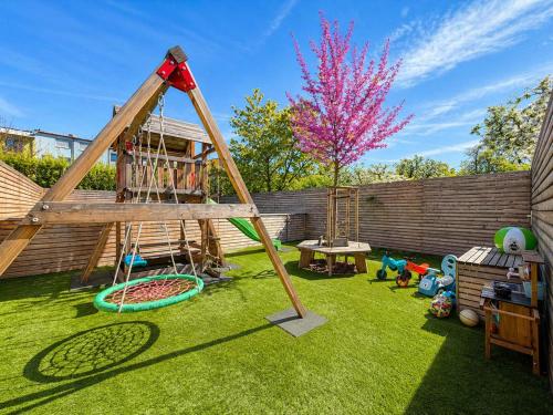 a playground with a swing and a tree at Čajkovskij Apartments in Brno