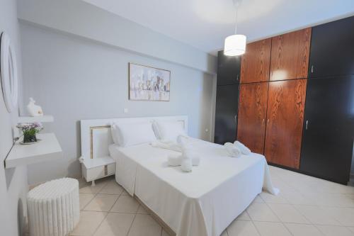 a white bedroom with a white bed and a table at Electras house in Kassandra