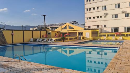 a swimming pool in front of a building at USCEESP Itanhaem in Itanhaém
