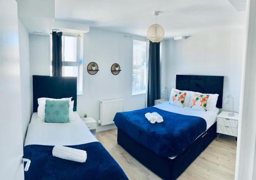 two beds in a room with blue and white at Folkestone Harbour Modern Comfortable Flat F3 in Folkestone