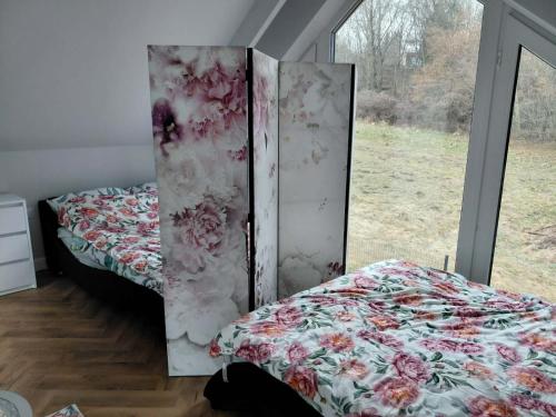 two beds in a room with a window at KLIMKOWSKA osada in Klimkówka