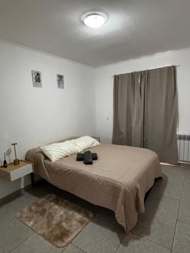 a bedroom with a bed in a room with a window at La Pampa Apartment in General Roca