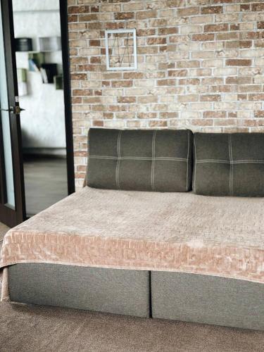 a bed in a room with a brick wall at Зелена долина in Solgutovo