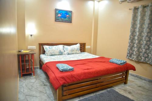 a bedroom with a bed with red sheets and a red blanket at JFZ Homestay in Kāsarkod