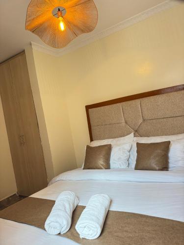 a bedroom with two beds with towels on them at SerenityLoft by Gloria in Thika