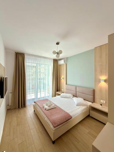 a bedroom with a large bed and a large window at Marconi Premium Apartments in Mamaia