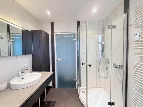 a bathroom with a glass shower and a sink at Seegarten Apartment 4 in Hagnau
