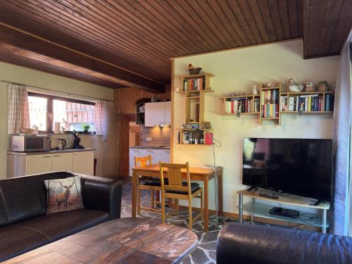a living room with a couch and a table and a television at Apartment Manderscheid near Castle Ruins in Manderscheid