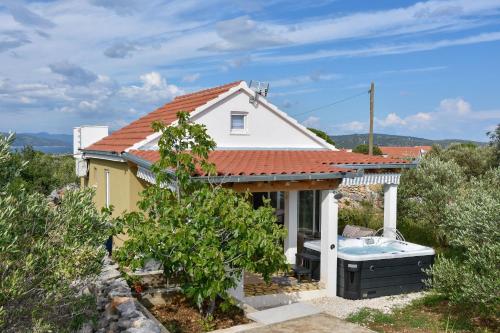 a small white house with a hot tub at House Lila Jacuzzy in Drvenik Mali