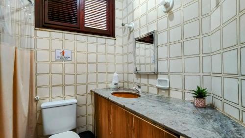 a bathroom with a sink and a toilet at Casa Mandacaru Pousada in Cumbuco