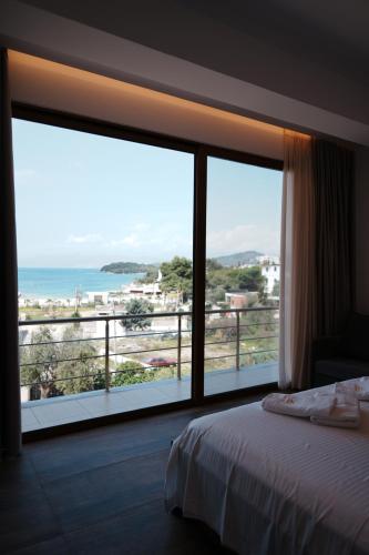 a bedroom with a large window with a view of the ocean at Hotel Lula Ksamil in Ksamil
